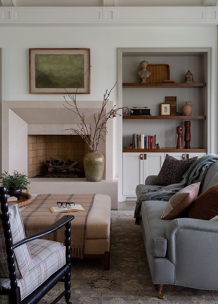 a living room filled with furniture and a fire place in the middle of it's wall