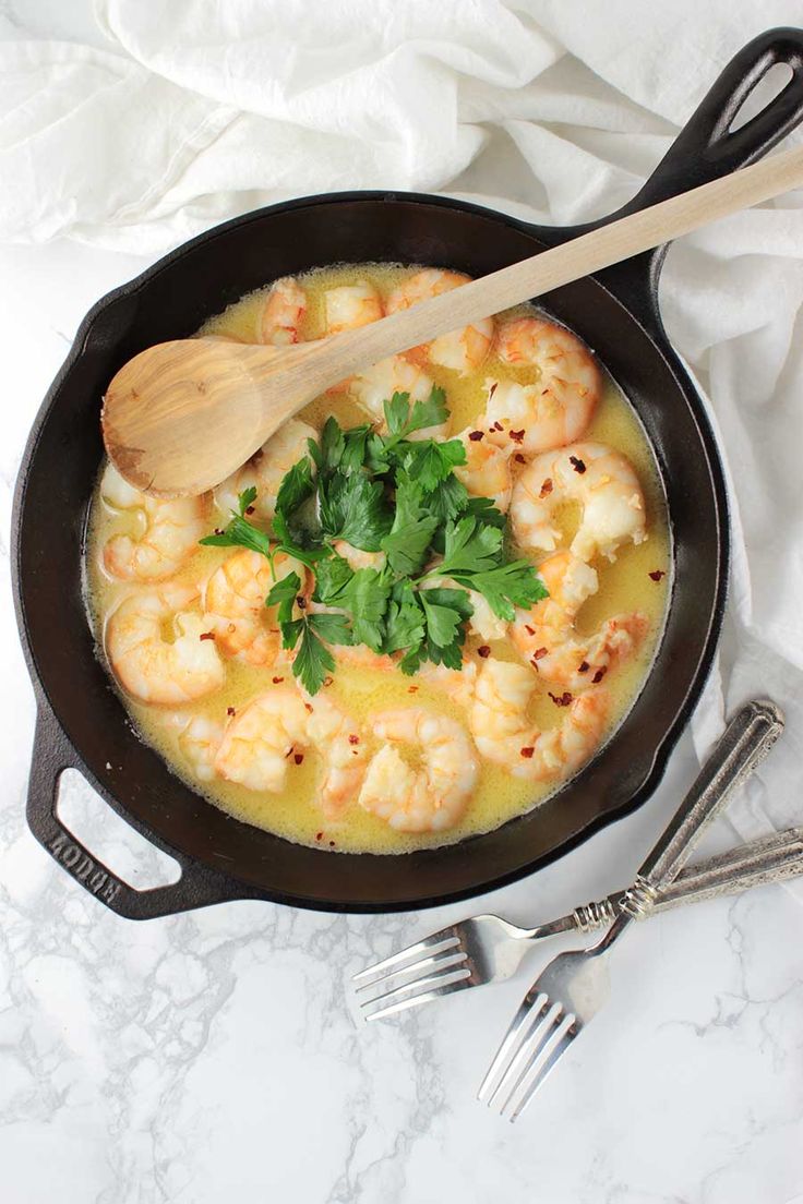 a skillet filled with shrimp and garnished with cilantro