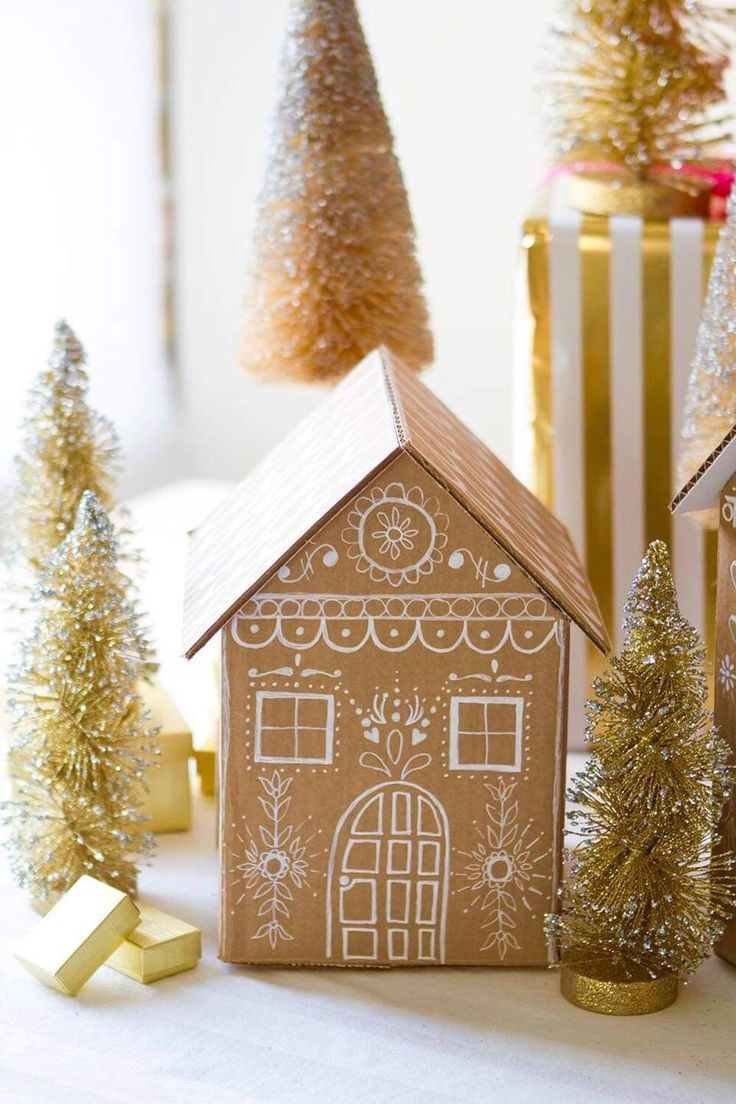 a gingerbread house sitting on top of a table next to christmas trees and presents