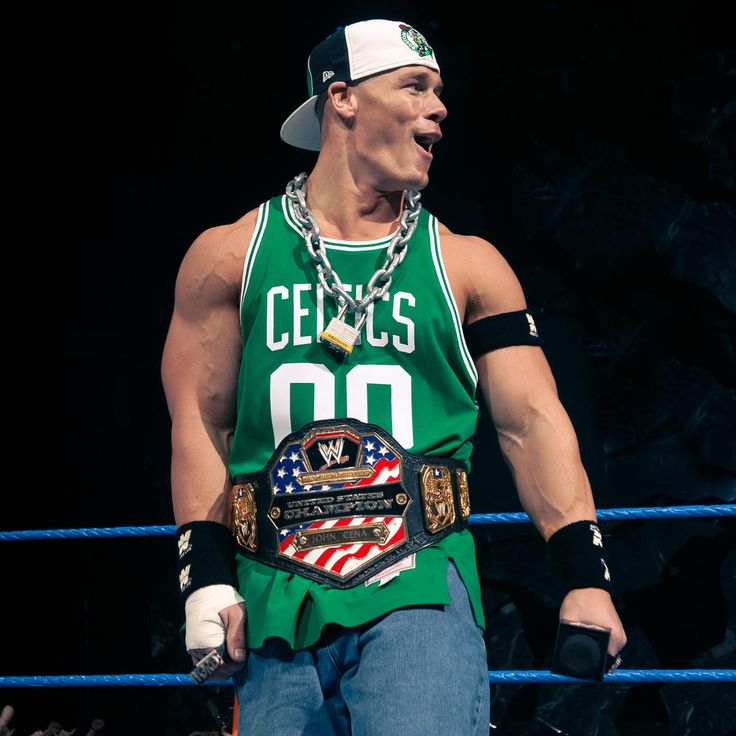 a man in a green shirt holding a wrestling belt