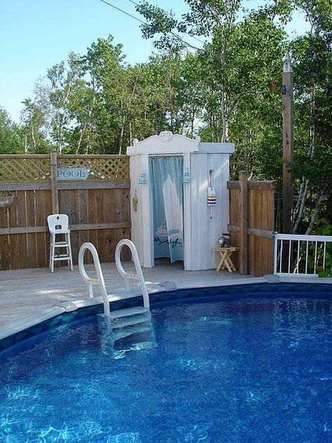 a small pool with a shower and chair next to it in front of a wooden fence