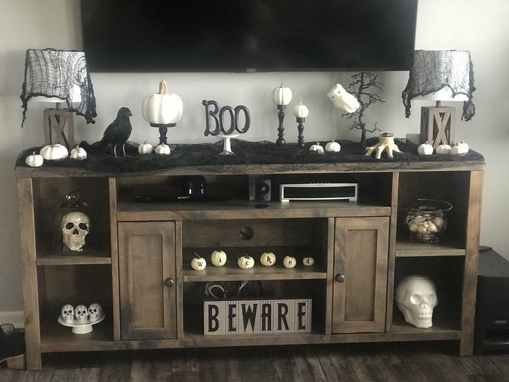 an entertainment center decorated for halloween with skulls and candles