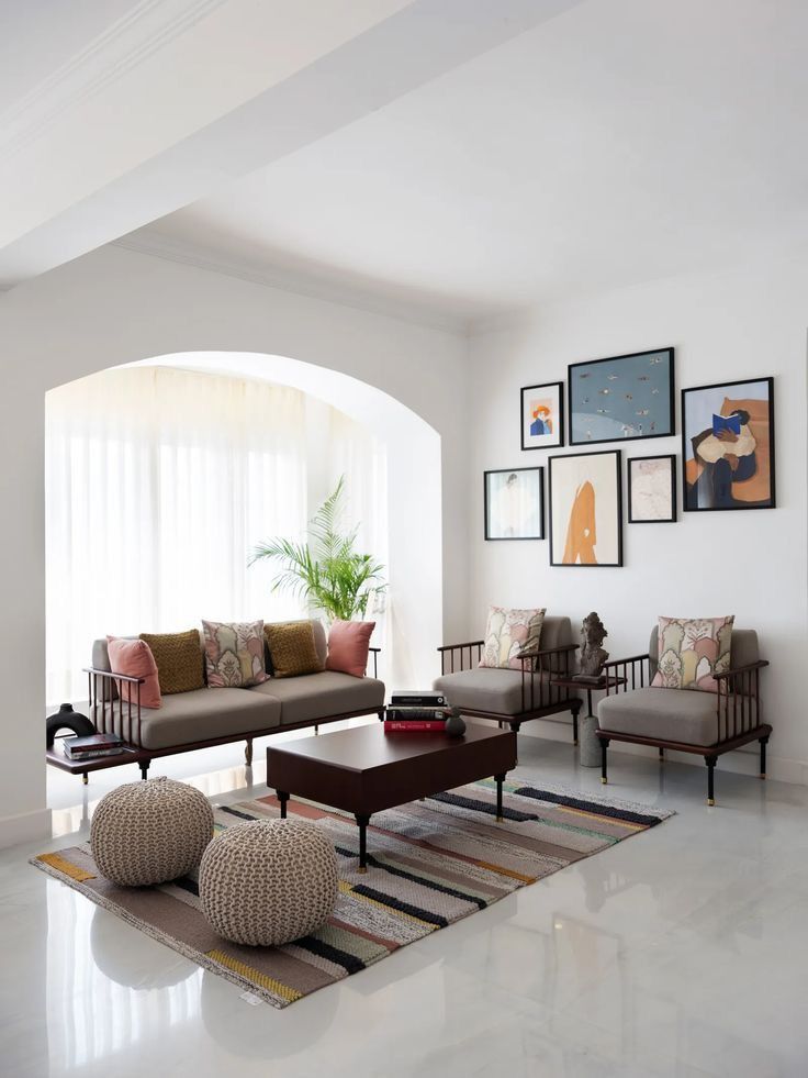 a living room filled with lots of furniture next to a wall mounted art piece on the wall