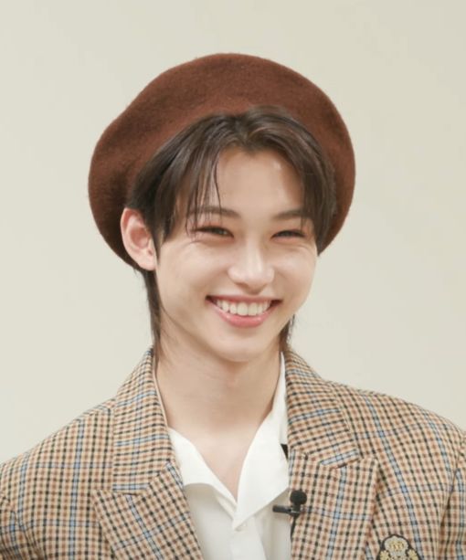 a young man wearing a brown hat and jacket