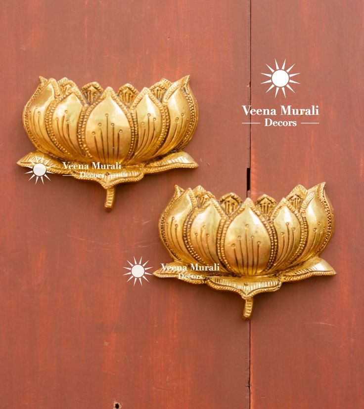 two golden flower decorations on the side of a wooden door