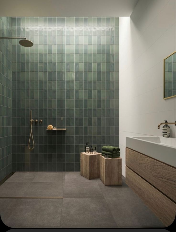 a modern bathroom with green tile on the walls