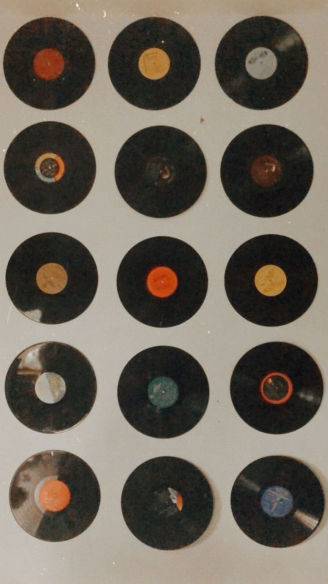 an assortment of records are arranged on a white surface with orange, black and gold discs