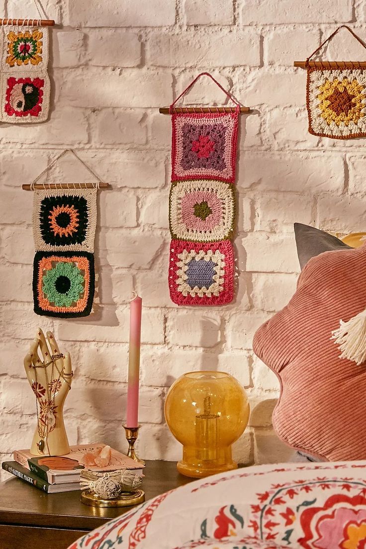 there are many crocheted wall hangings on the brick wall in this room