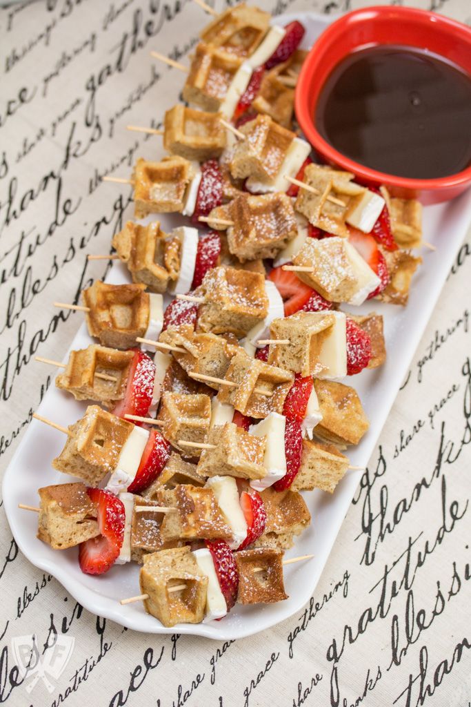 strawberries and cheese skewers on a plate with dipping sauce