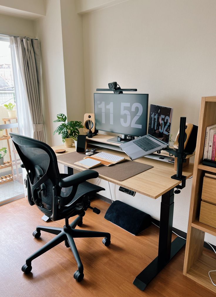 a computer desk with a monitor, keyboard and mouse on it in front of a window