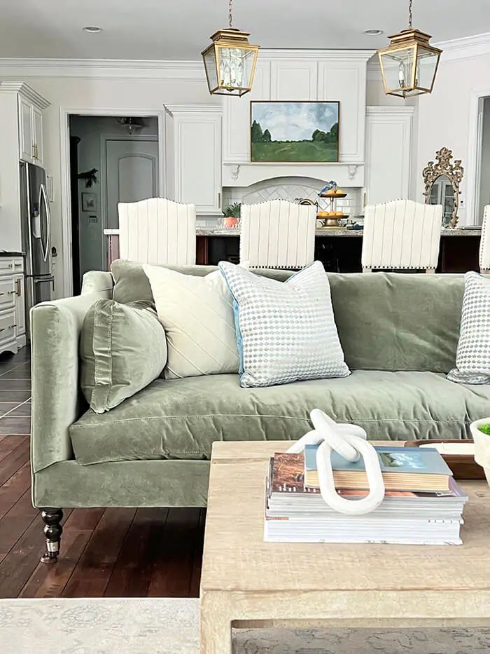 a living room filled with furniture and a coffee table in front of a kitchen area