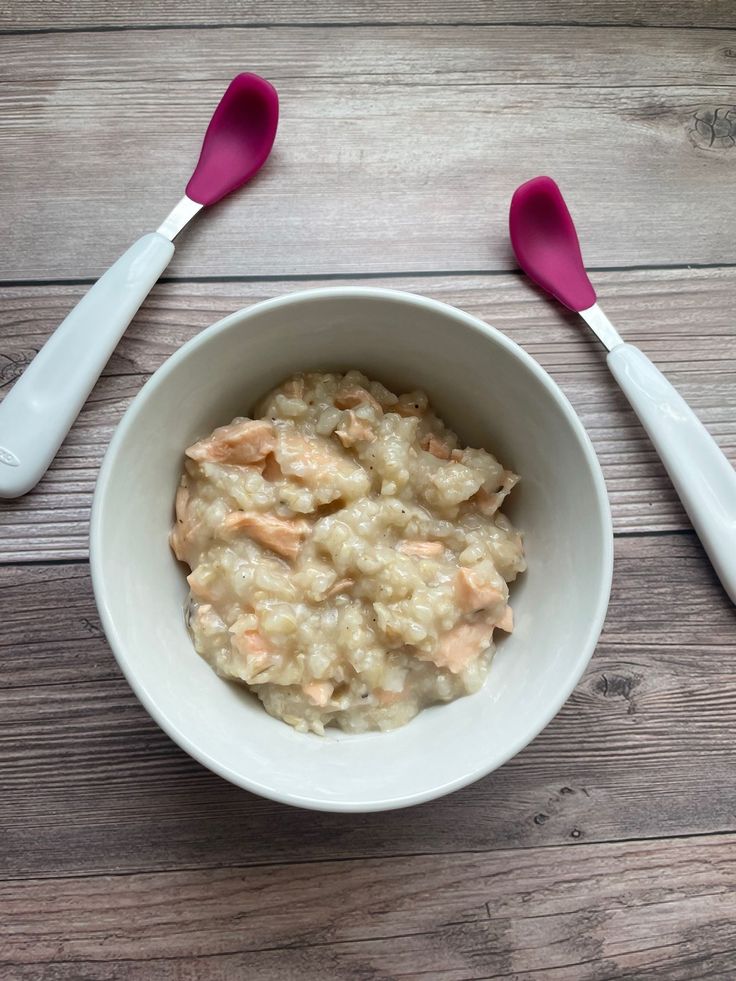 a bowl of oatmeal with two spoons on the side