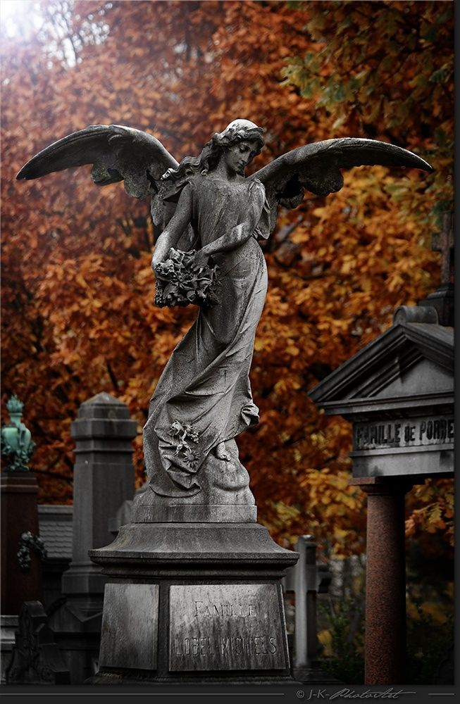 an angel statue in front of a cemetery