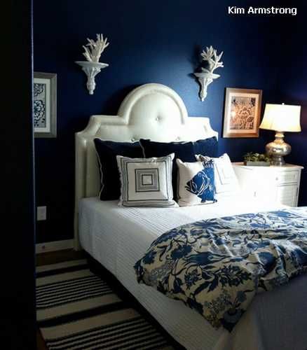 a bedroom with blue walls and white bedding