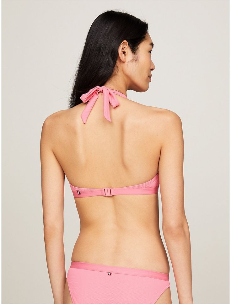 Tommy Hilfiger women's swimwear. The flirty halter neck fastening and iconic logo detailing at the underband lends a playful feel to this triangle bikini top.  Material: 94% Recycled Nylon ,  Polyamide, 6% Elastane. Pink Triangle Swimwear For Spring, Nylon Swimwear With Triangle Top And Bra Friendly, Nylon Triangle Top Swimwear, Bra-friendly, Nylon Triangle Top Swimwear For Spring, Nylon Triangle Top Swimwear That Is Bra Friendly, Bra Friendly Nylon Swimwear With Triangle Top, Spring Nylon Triangle Top Swimwear, Spring Triangle Top Nylon Swimwear, Bra-friendly Nylon Triangle Swimwear