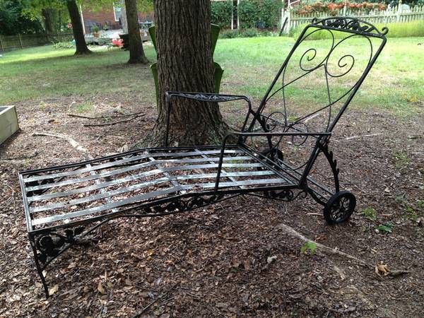 an old metal bed sitting under a tree