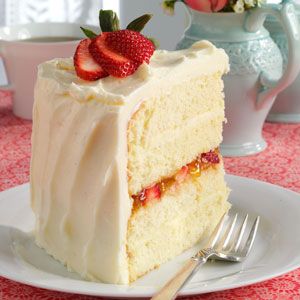 a piece of cake with white frosting and strawberries on top