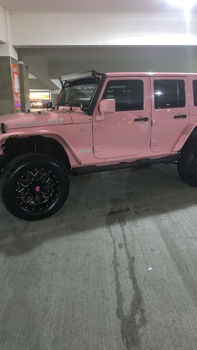 a pink jeep parked in a parking garage