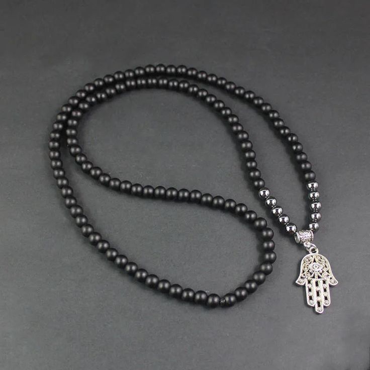 Inspired by Middle Eastern symbolism, the striking beauty of this Natural Onyx Beaded Long Necklace has a unique versatility and can easily be worn by either men or women. With a longer length design, this decorative piece features naturally toned Onyx beads - each unique in their design and boasting a gentle array of colour. Breaking up the darkened silhouette are three intricate skull beads and glass charms that capture the light and emit a colourful array. The necklace has been finished off w Symbolic Black Jewelry With 108 Beads, Spiritual Black Beaded Necklaces, Spiritual Black Beaded Necklaces For Meditation, Black Polished Beads Necklace For Healing, Black Spiritual Beaded Necklaces With Polished Beads, Adjustable Onyx Beaded Necklace With Black Beads, Adjustable Onyx Necklace With 8mm Beads, Onyx Beaded Jewelry For Meditation, Black Polished Beads Necklace For Meditation