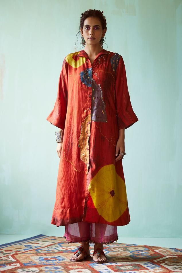 Orange habutai silk tunic with tie-dye pattern, bandhani placement print and sequins and thread hand embroidery. Comes with tissue pant.
Components: 2
Pattern: Printed, Hand embroidered
Type Of Work: Tie-Dye, Bandhani, Sequins, Thread
Neckline: Collar
Sleeve Type: Three quarter
Fabric: Tunic: Habutai silk, Pant: Tissue
Color: Orange
Other Details: 
Closure: Front buttons
Note: Dupatta worn by the model is not for sale.
Occasion: Mehendi and Haldi - Aza Fashions Traditional Silk Tunic For Spring, Silk Tunic Straight Kurta For Spring, Silk Kurta With Printed Motifs, Transitional Silk Kurta With Printed Motifs, Silk Tunic Kurta With Resham Embroidery, Long Silk Kurta For Summer, Bohemian Cotton Silk Long Sleeve Kurta, Silk Kurta With Resham Embroidery Tunic, Long Silk Kurta For Festivals