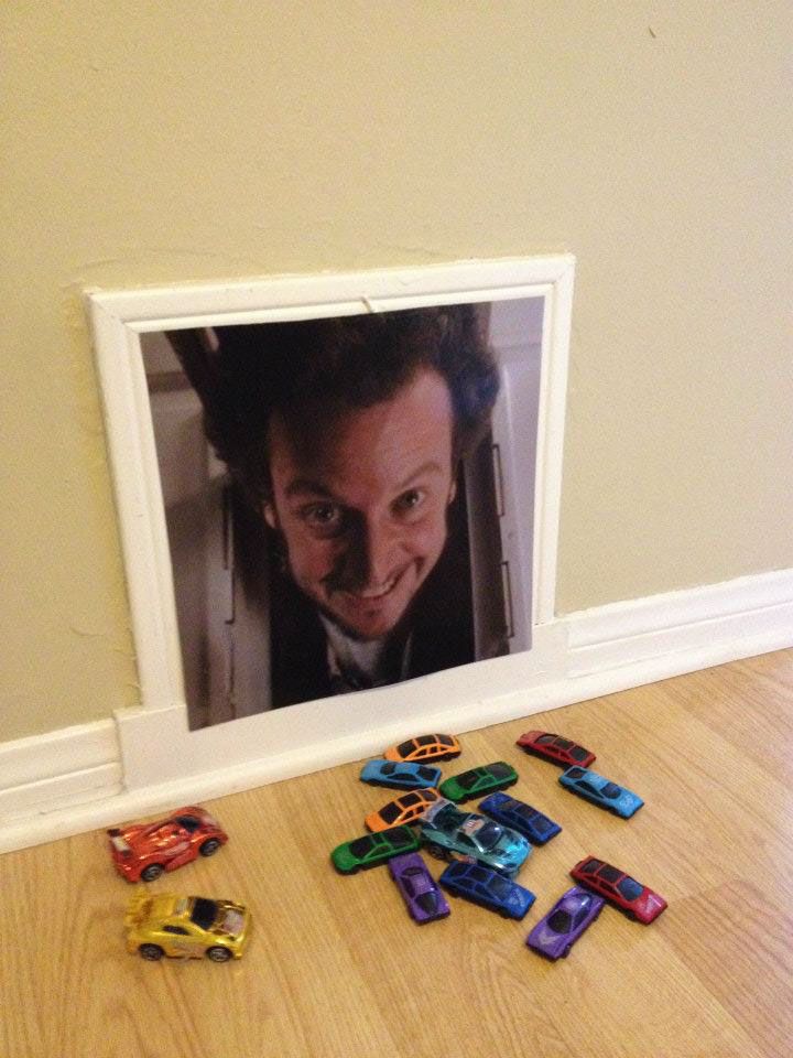 there are many toy cars laying on the floor next to a framed photo with a man's face