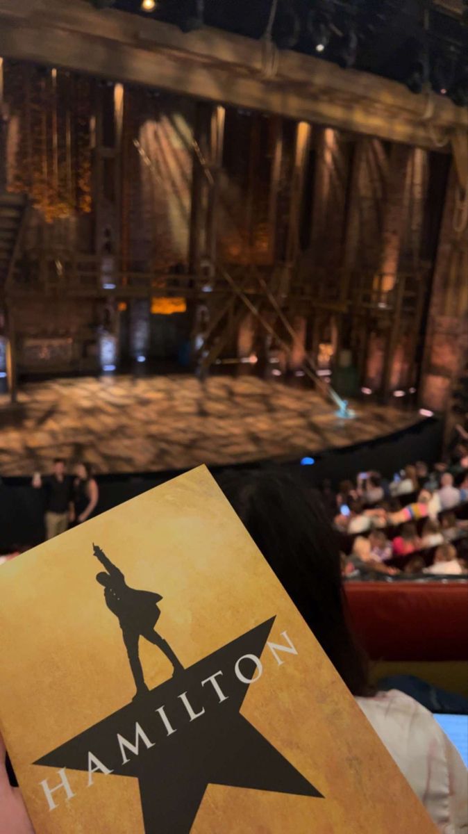 someone holding up a book in front of a stage