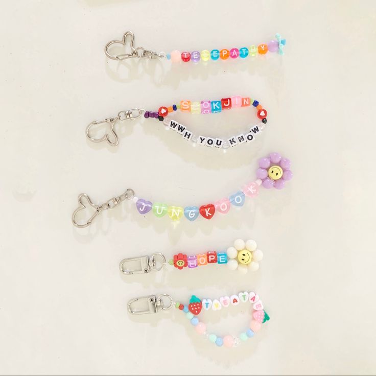 four keychains with different designs and words on them, all decorated in various colors