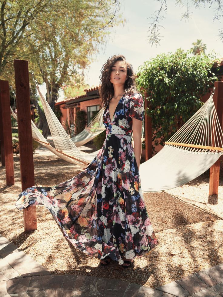 a woman in a long dress standing on a hammock