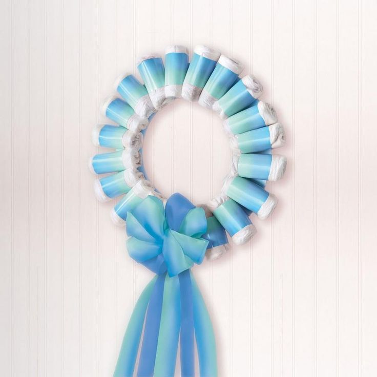 a blue and white ribbon is tied to a ring shaped hair accessory on a wall