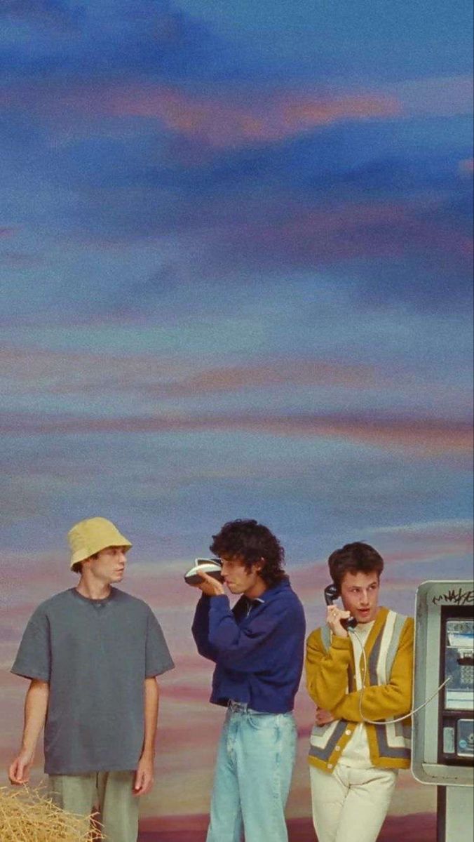 three men standing next to each other in front of a parking meter with a sky background