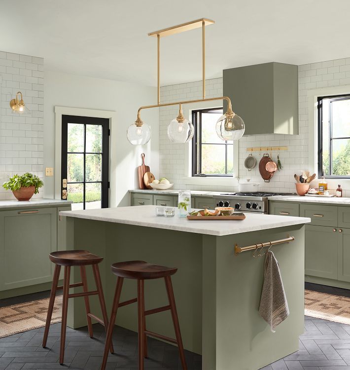 a kitchen with two stools next to an island