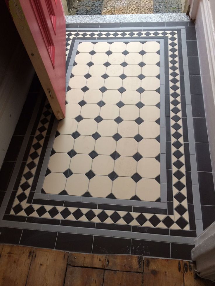 a black and white tile floor with red door in the background, next to a doorway