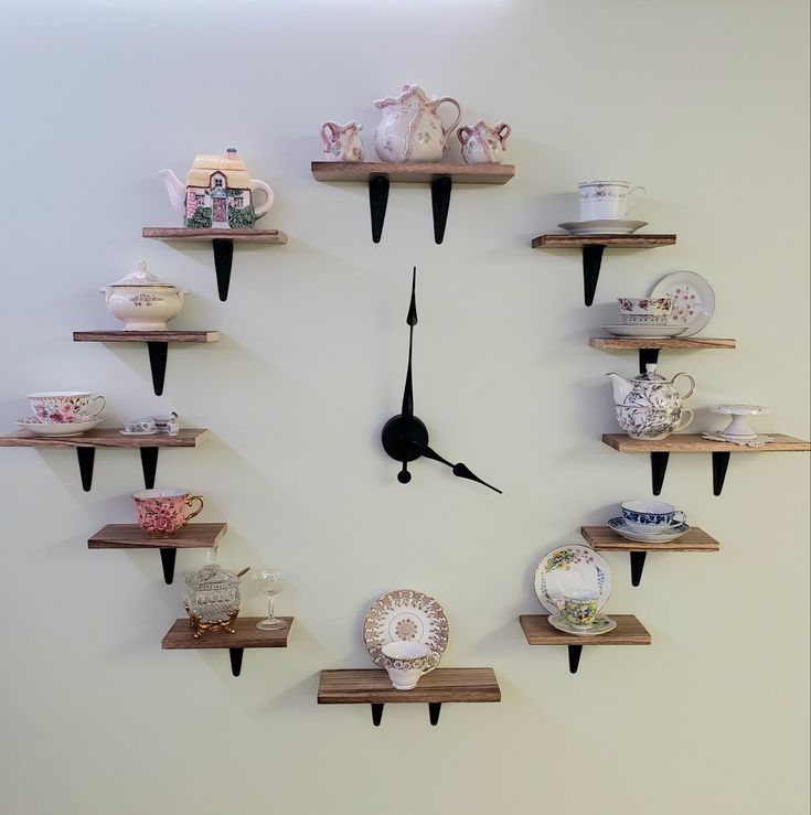 a clock that is on the wall with some shelves in front of it and plates