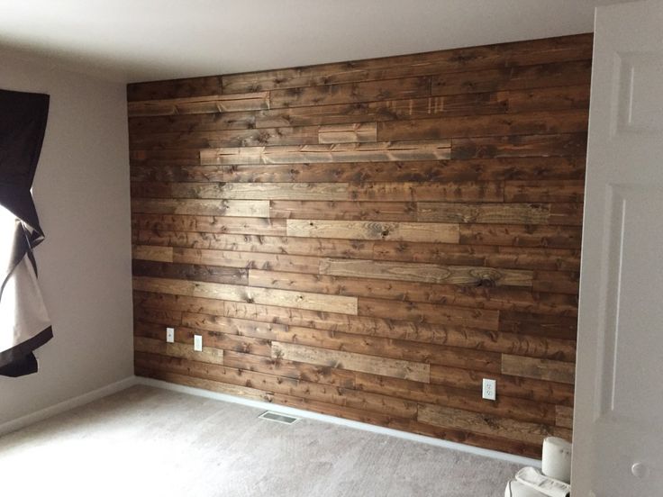 an empty room with wood paneling on the wall