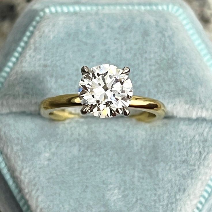 a diamond ring sitting on top of a velvet box