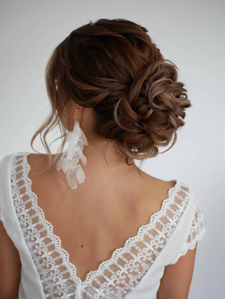 the back of a woman's head, with her hair in a low bun