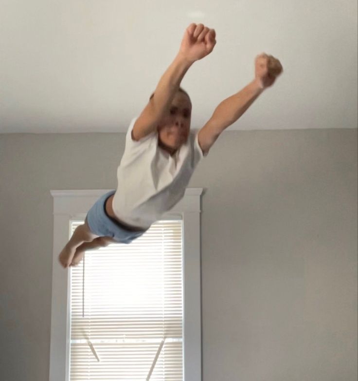 a young boy is jumping in the air on his bed