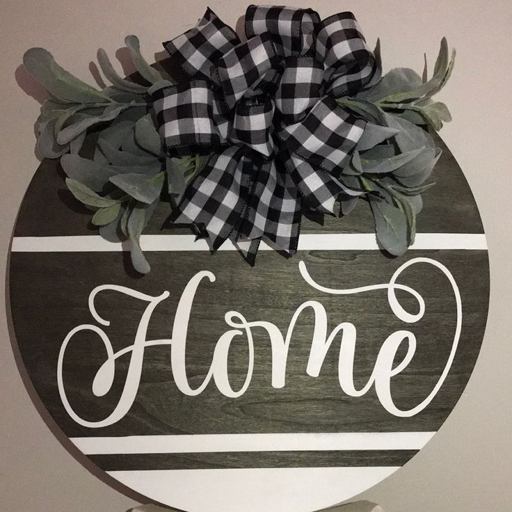 a wooden sign with the word home painted on it's side and a bow