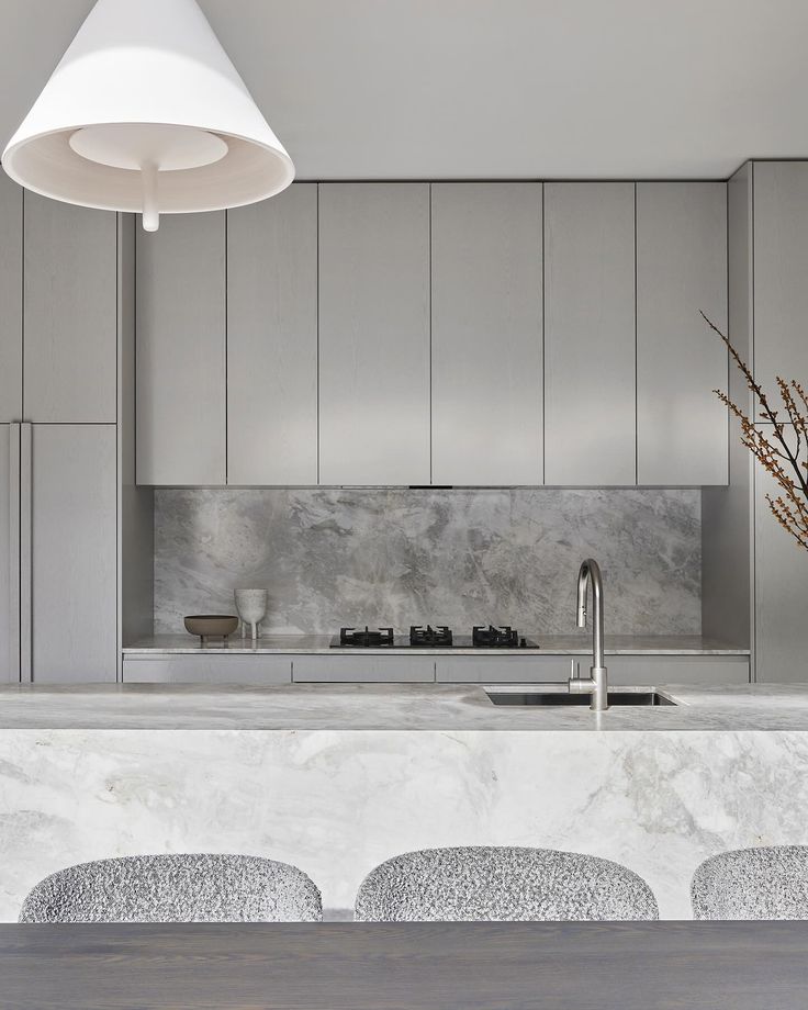 a kitchen with marble counter tops and stools