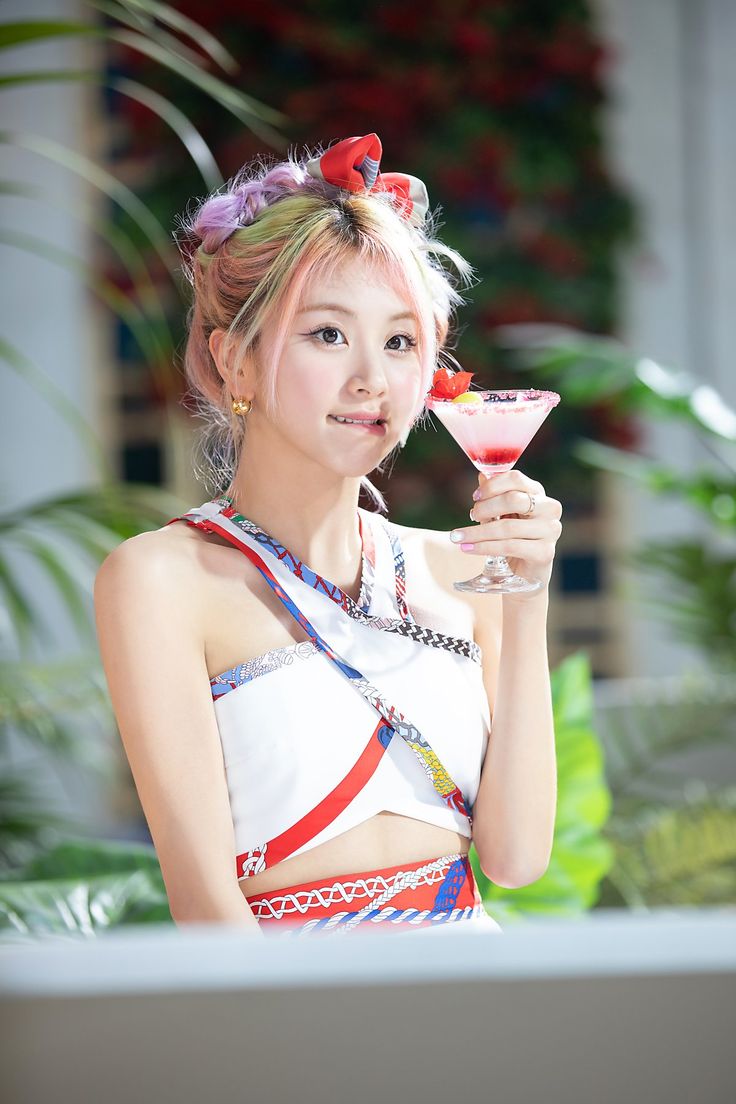 a young woman holding a martini glass and looking at the camera