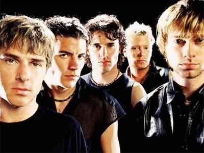 a group of young men standing next to each other in front of a black background