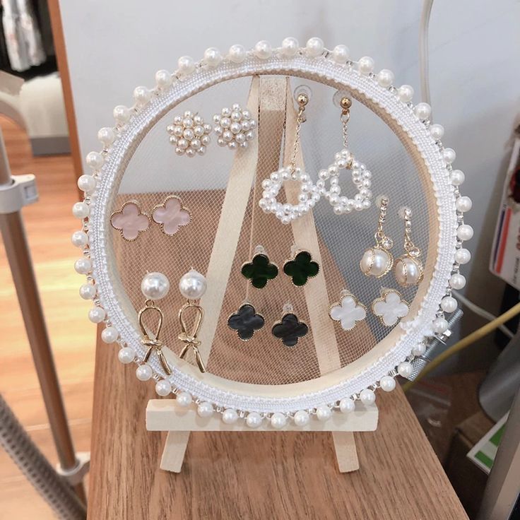 a wooden table topped with lots of earrings