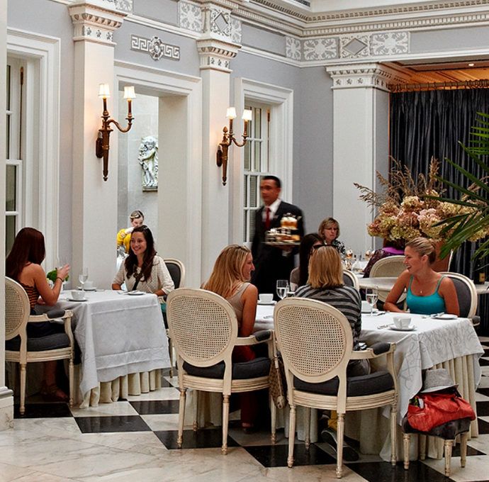 people sitting at tables in a restaurant with black and white checkered flooring