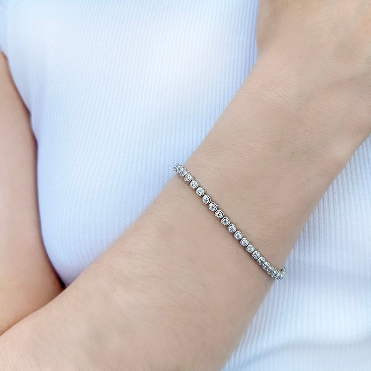 Up your game with our Charlotte Bezel Set Bracelet, featuring a flexible, continuous line of sparkling gemstones with a box and tongue clasp. A luxurious "tennis style" design made famous by tennis champion Chris Evert, who wore hers during the 1987 US Open. Both sporty and chic, this versatile bracelet style fits our modern classic aesthetic perfectly. Cubic Zirconia 14k gold vermeil, or rhodium finished sterling silver 3mm diameter stones Nickel free Comes in a signature pouch with box Remove Bezel Set Necklace, Chris Evert, Tennis Champion, Tennis Style, Ring Guide, Set Bracelet, Classic Aesthetic, Bracelet Style, Continuous Line