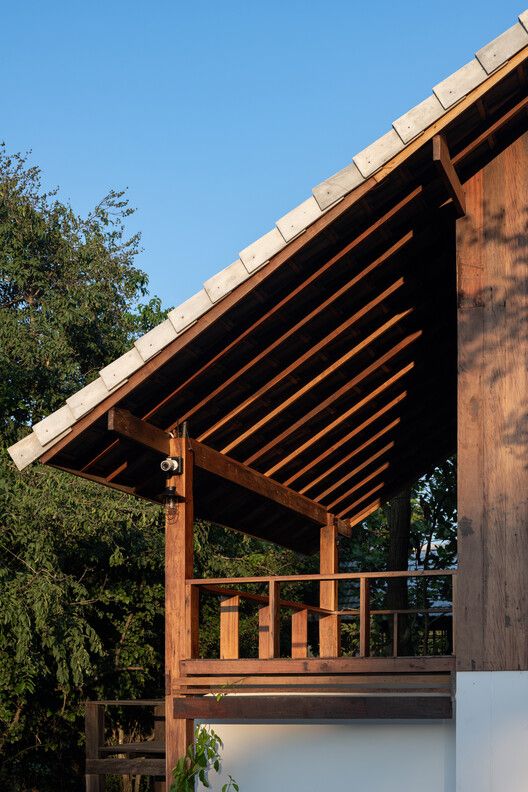 a wooden structure sitting on the side of a building next to a lush green forest