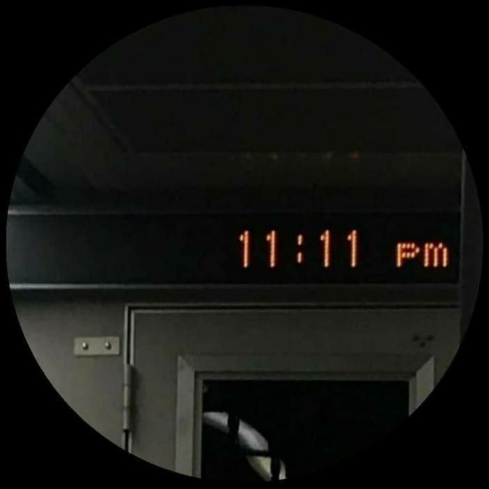 a clock that reads 11 11 pm in front of an open door with the time on it