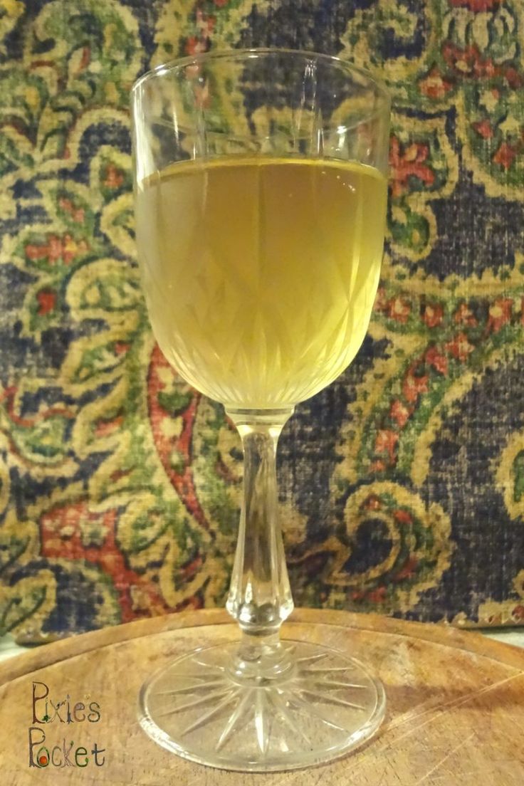 a glass of wine sitting on top of a wooden table