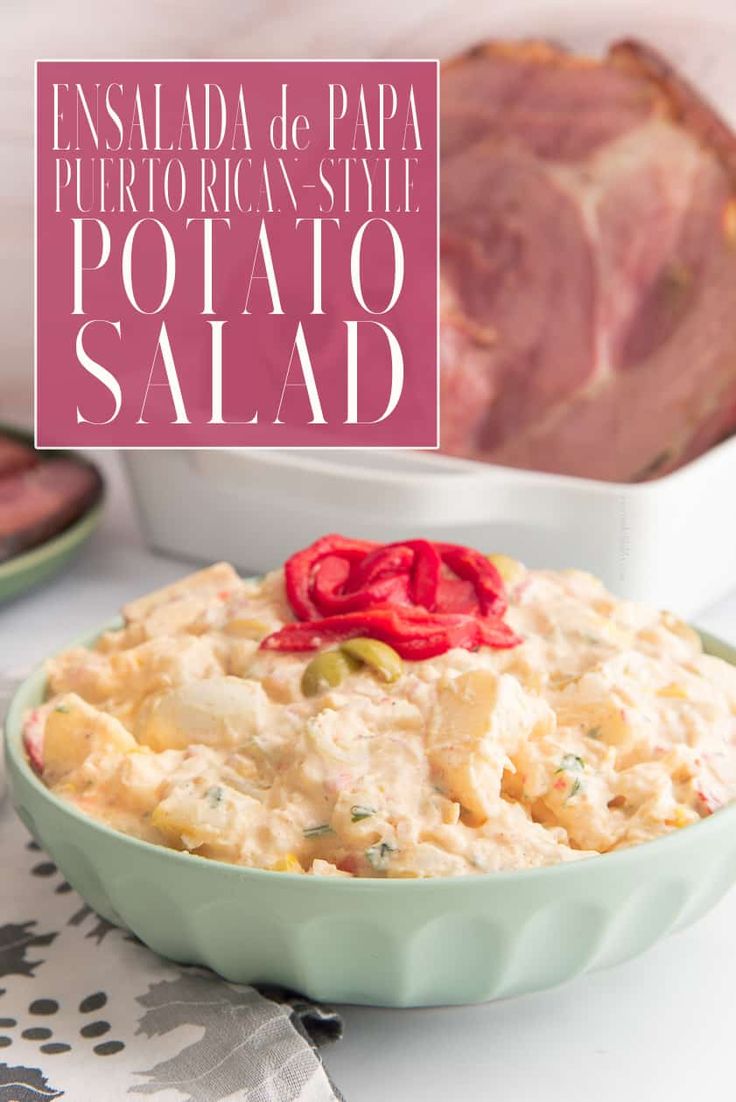 a bowl filled with potato salad next to meat