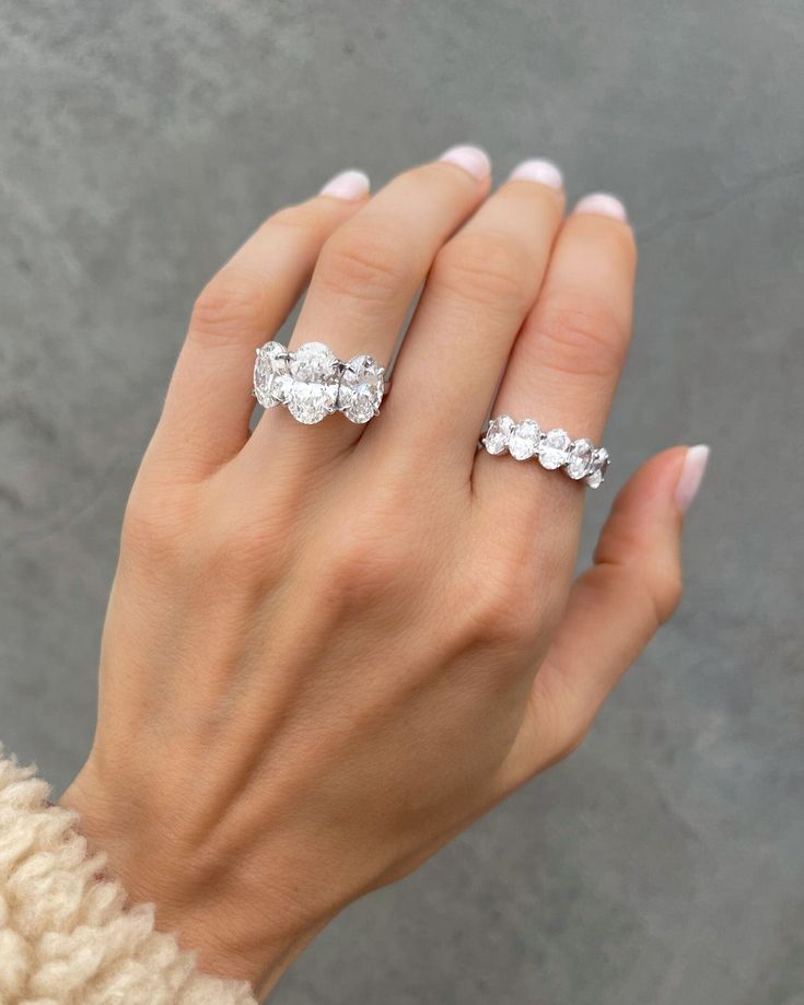 a woman's hand with three stone rings on her left and the middle finger