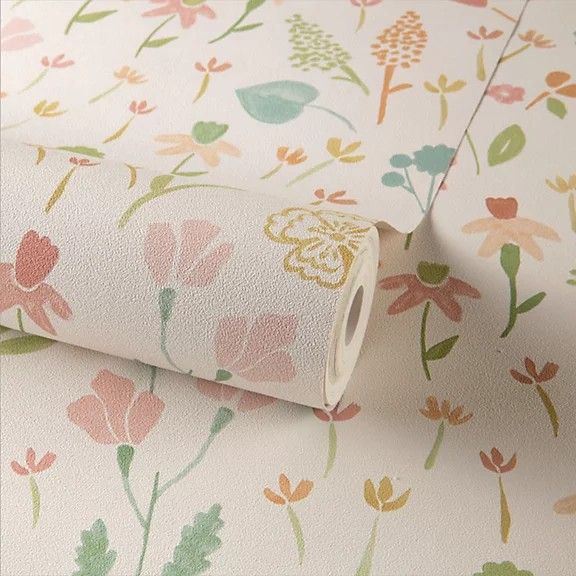 a roll of toilet paper sitting on top of a flowered wallpaper covered in pink and green flowers